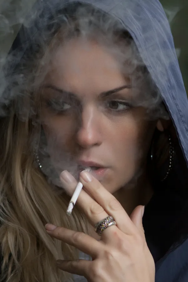 young attractive woman wearing a hoodie and smoking