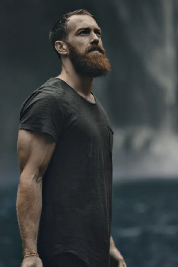 man with beard wearing dark t-shirt looking up
